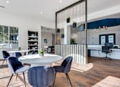 Thumbnail 28 of 35 - A modern dining room with a white table and blue chairs.