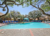 Thumbnail 36 of 45 - A swimming pool surrounded by trees and chairs.