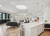 Thumbnail 39 of 70 - A modern kitchen with a white countertop and a black sofa.