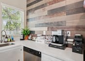 Thumbnail 41 of 70 - A kitchen with a wooden backsplash and a coffee maker on the counter.