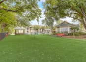 Thumbnail 36 of 44 - a park with a red bench in front of a house