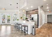 Thumbnail 43 of 70 - A kitchen with a white counter and bar stools.
