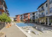 Thumbnail 32 of 37 - an apartment building with a pool and lounge chairs