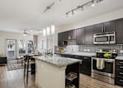 Thumbnail 2 of 30 - A modern kitchen with dark wood cabinets and stainless steel appliances.