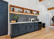 Thumbnail 51 of 79 - A kitchen with dark cabinets and a brick wall.