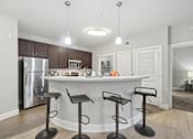 Thumbnail 4 of 40 - A kitchen with a bar and stools.