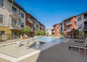 Thumbnail 33 of 37 - an apartment building with a pool and chairs in front of it