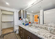 Thumbnail 14 of 49 - A bathroom with a marble countertop and a striped rug.