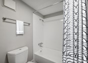 Thumbnail 9 of 41 - a bathroom with a shower curtain and a toilet