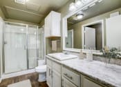Thumbnail 7 of 33 - a bathroom with a shower and a sink and a mirror