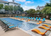 Thumbnail 37 of 50 - a swimming pool with blue chairs and yellow and orange chairs