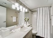 Thumbnail 7 of 27 - a bathroom with a sink and a mirror and a shower