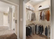 Thumbnail 11 of 42 - a walk in closet with a mirrored closet door and a closet full of clothes