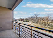 Thumbnail 17 of 49 - A balcony with a view of a road and trees.