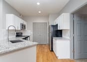 Thumbnail 7 of 17 - a kitchen with white cabinets and a sink and a refrigerator