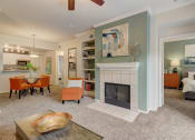 Thumbnail 2 of 44 - a living room with a fireplace and a table and chairs
