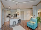 Thumbnail 18 of 52 - a living room with a kitchen with a bar and a blue chair
