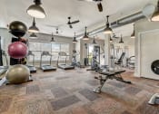Thumbnail 17 of 42 - a gym with weights machines and lights on the ceiling