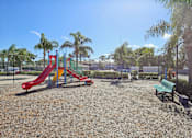 Thumbnail 19 of 25 - A playground with a red slide and green bench.