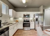 Thumbnail 3 of 33 - a kitchen with stainless steel appliances and white cabinets