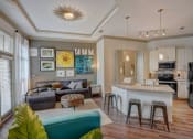 Thumbnail 20 of 52 - a living room with a kitchen and a bar with stools