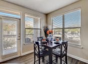 Thumbnail 6 of 50 - a dining room with two windows and a table with chairs