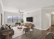 Thumbnail 20 of 70 - A living room with a grey couch, a wooden coffee table, and a flat screen TV mounted on the wall.