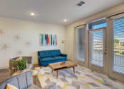 Thumbnail 17 of 44 - a living room with a blue couch and a coffee table