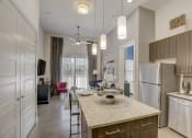 Thumbnail 10 of 37 - a kitchen with an island and a living room with a refrigerator