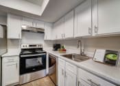 Thumbnail 4 of 27 - a kitchen with white cabinets and appliances and a sink