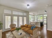 Thumbnail 4 of 36 - a living room with a couch and a table and a kitchen
