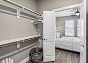 Thumbnail 9 of 36 - A bedroom with a bed, a window with blinds, and a basket on the floor.