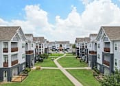 Thumbnail 64 of 70 - A row of modern townhouses with a grassy area in the foreground.