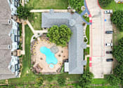 Thumbnail 62 of 70 - A bird's eye view of a residential area with a swimming pool and a playground.