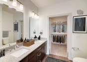 Thumbnail 7 of 44 - a bathroom with a sink and a mirror and a closet