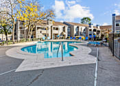 Thumbnail 26 of 37 - our apartments have a swimming pool with chairs and apartment buildings in the background