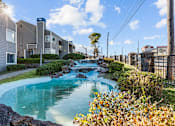 Thumbnail 23 of 37 - a small pool with waterfalls in front of apartment buildings