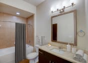Thumbnail 9 of 36 - a bathroom with a sink and a mirror and a shower