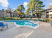 Thumbnail 25 of 37 - the preserve at ballantyne commons pool with blue chairs and apartment buildings