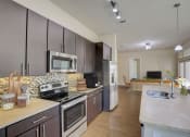 Thumbnail 6 of 36 - a large kitchen with stainless steel appliances and marble counter tops
