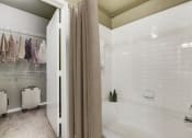 Thumbnail 11 of 33 - a bathroom with a tub and shower and a shower curtain
