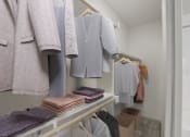 Thumbnail 7 of 37 - a walk in closet with a rack of clothes and a mirror