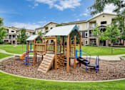 Thumbnail 19 of 22 - A playground with a wooden swing set and a blue slide.