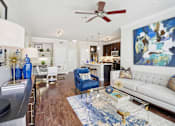 Thumbnail 6 of 33 - a living room with a white couch and a ceiling fan