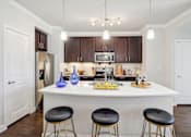 Thumbnail 8 of 33 - a kitchen with a large island with three stools