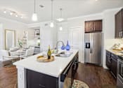 Thumbnail 10 of 33 - a kitchen with a large island and a stainless steel refrigerator