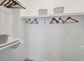 Thumbnail 22 of 33 - a walk in closet with hooks and a white wall