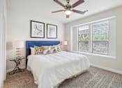 Thumbnail 14 of 33 - a bedroom with a bed and a ceiling fan