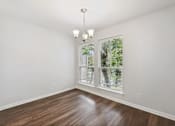Thumbnail 7 of 79 - an empty living room with a large window and wooden floors