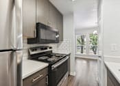 Thumbnail 2 of 79 - an empty kitchen with a stove and a microwave